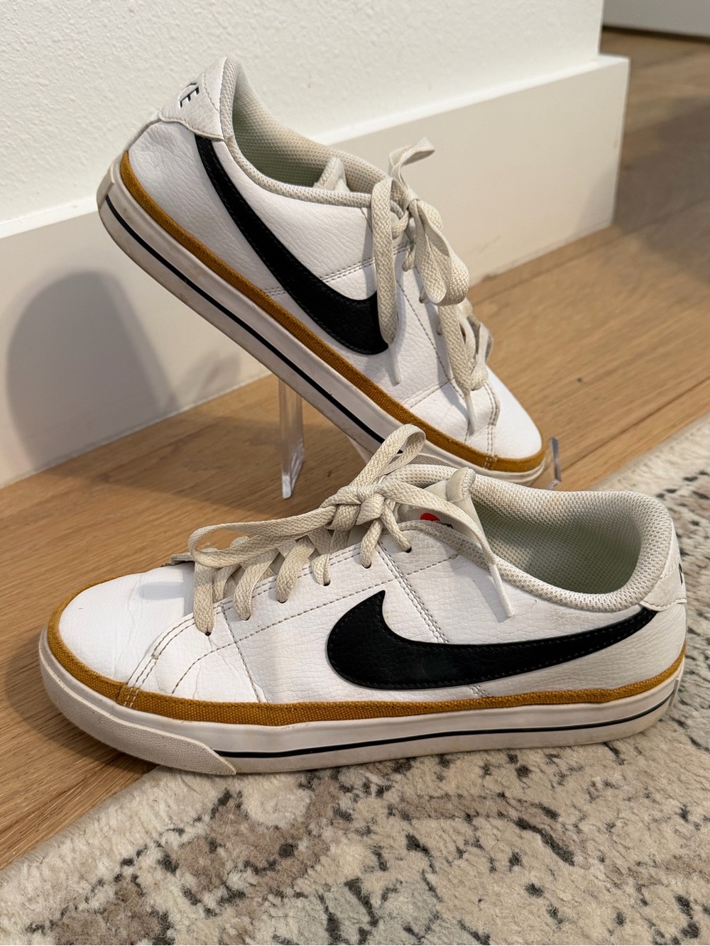 Nike White Sneakers with Black Swoosh and Gold Accent